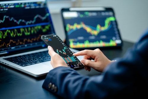 Investors analyze the data stock market index via smartphone screen to trade